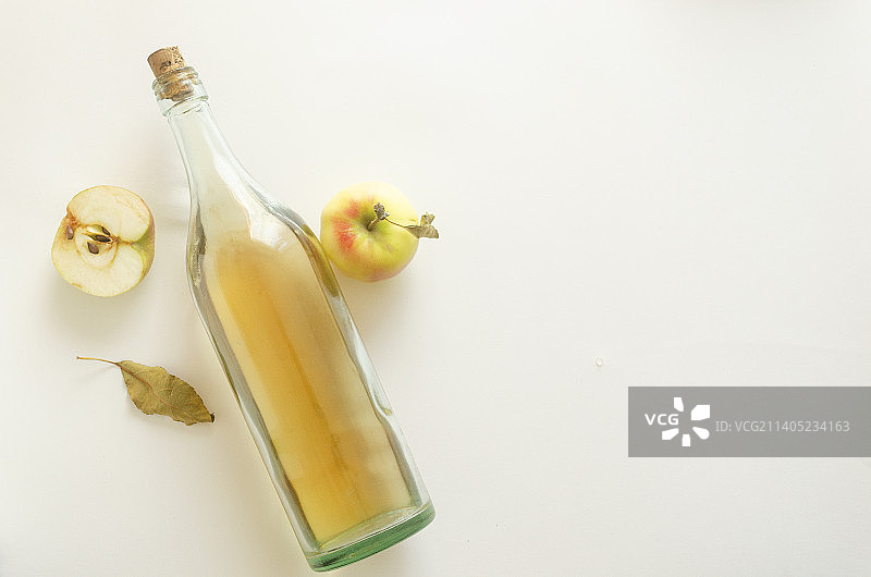 俯视视角，白背景上的苹果醋瓶和苹果图片素材