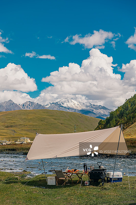 塔公草原古弄村草地河边上露营欣赏远方的雅拉雪山风景图片素材