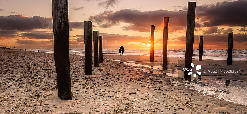 日落时分荷兰佩滕海滩上的人群剪影图片素材