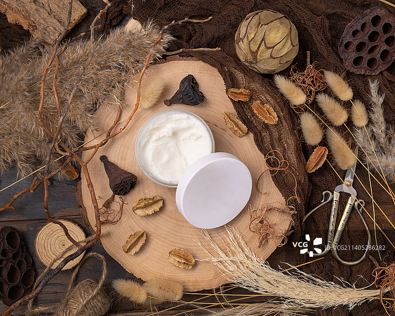 打开的奶油罐，木头上带有空白盖子，靠近自然装饰品的顶部视图，包装模型图片素材