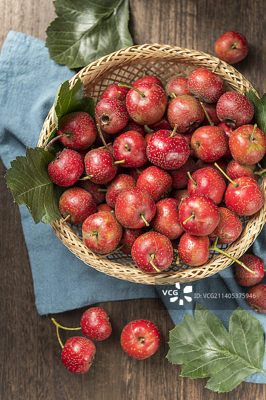 一簸箕山楂红果摆放在桌面上特写图片素材