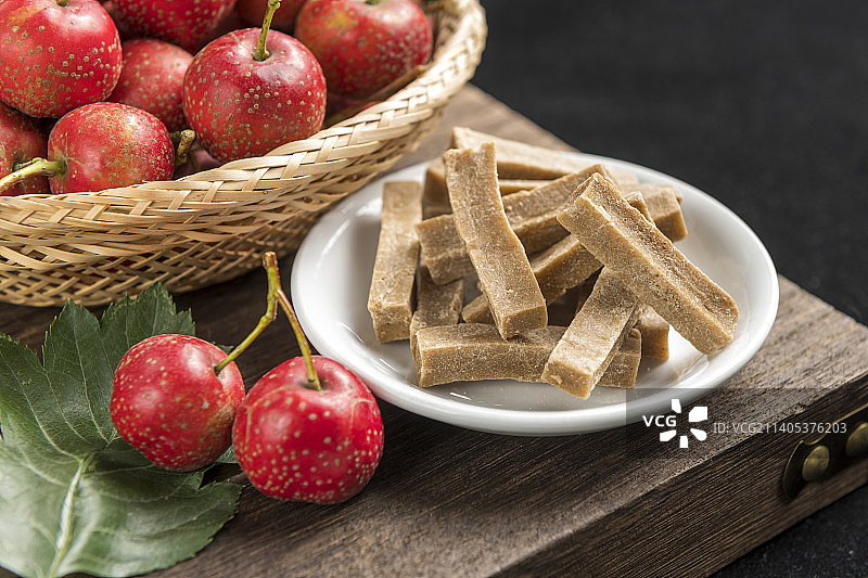 一盘山楂条与红果摆放在桌面上特写图片素材