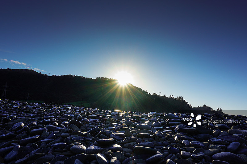 新西兰罗宾汉湾岩石映衬晴朗蓝天美景图片素材