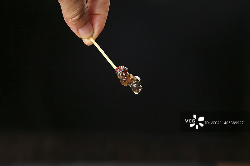 牙签上插着香辣田螺肉图片素材