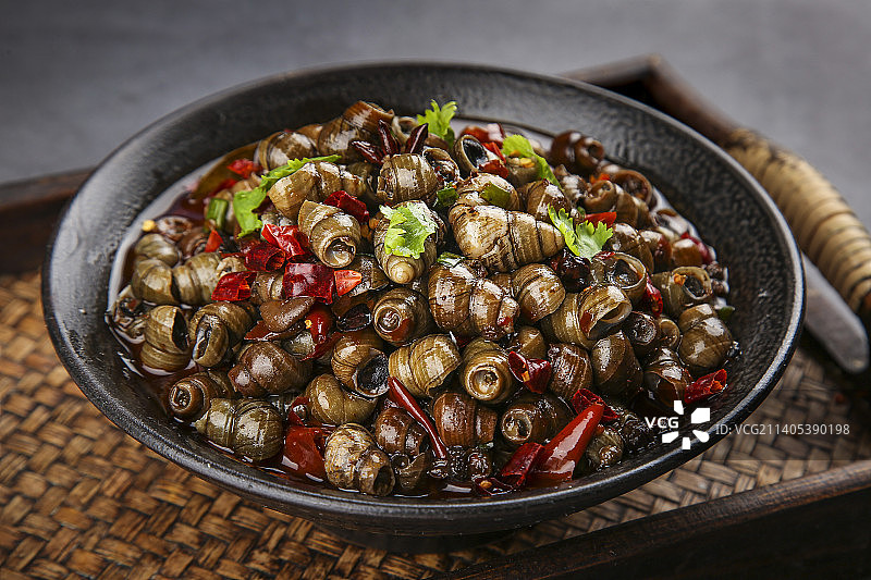 木盘里的一碗香辣田螺图片素材