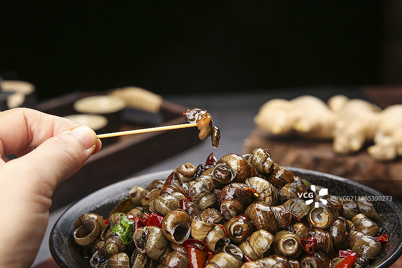 牙签上插着香辣田螺肉图片素材