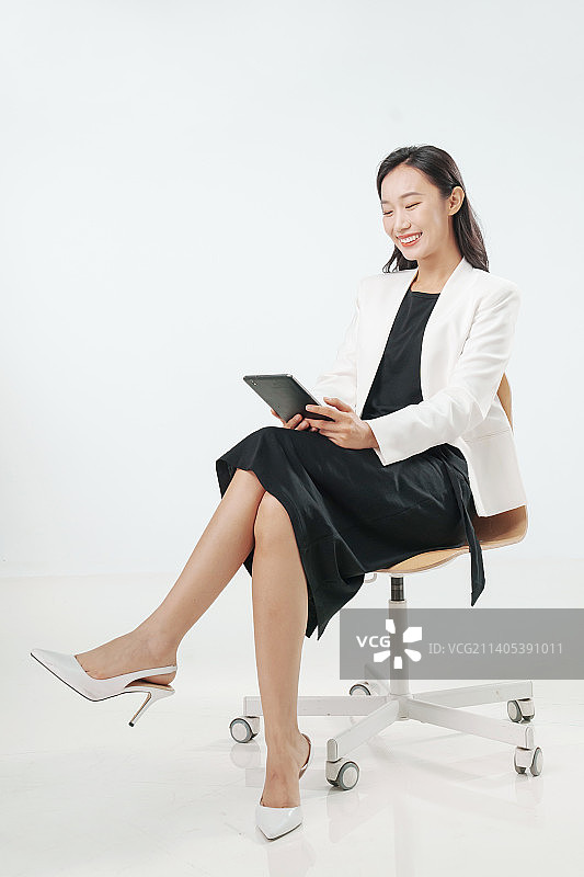 商务女士坐在椅子上看平板电脑图片素材