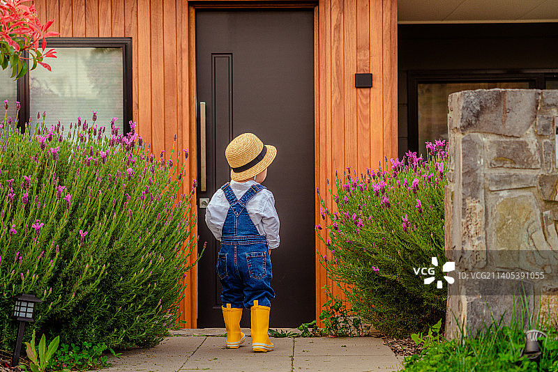别墅庭院前的戴礼帽的时尚男孩图片素材