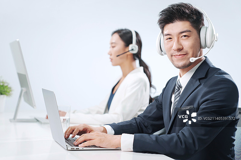 带耳机工作的商务人士图片素材