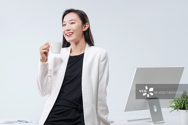 商务女士站在办公桌前喝水图片素材
