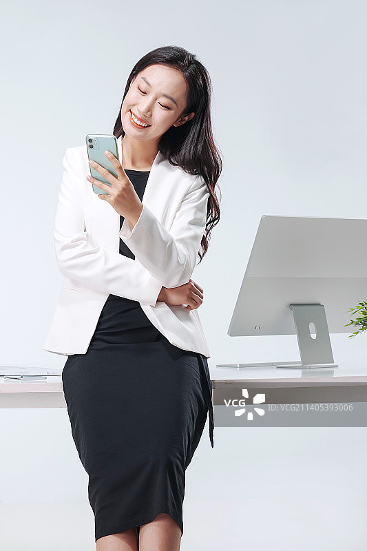拿着手机的商务女士在办公室图片素材