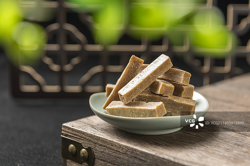 一盘山楂条与茶水摆放在古窗棂木桌面上图片素材