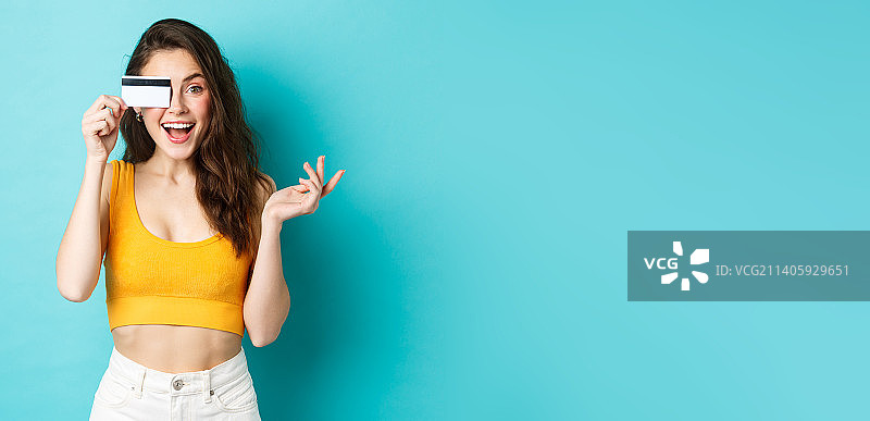 兴奋的美女穿着夏季露脐装，惊讶地看着镜头图片素材