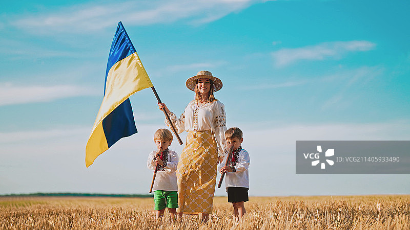 乌克兰母亲和儿子在麦田挥舞国旗图片素材