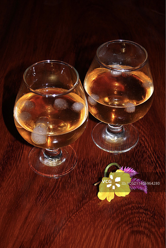 高角度拍摄：桌上摆放着盛有鲜花的葡萄酒杯图片素材