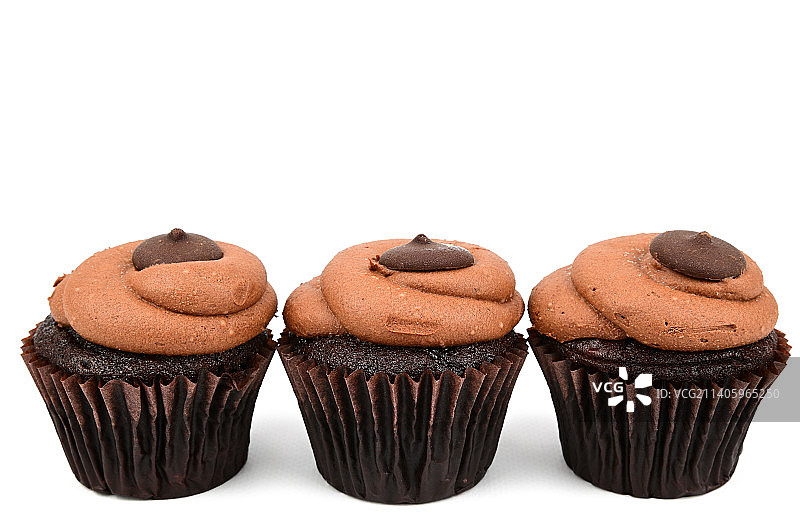 一排三个纸杯蛋糕，蛋糕放在装饰纸托里图片素材