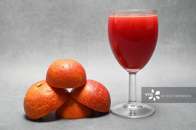 一杯鲜榨血橙汁，旁边放着挤过的果皮图片素材