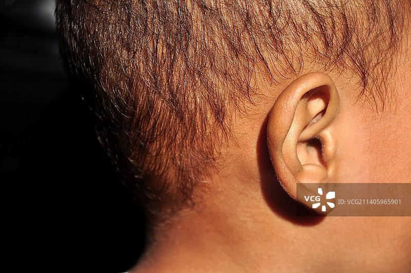 黑色背景上的亚洲幼儿耳朵特写图片素材