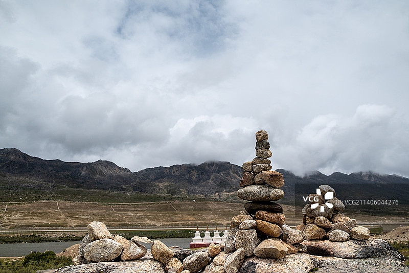 川西冷嘎措玛尼堆多云的天空映衬下的岩石景观图片素材