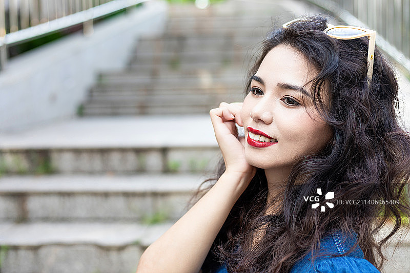 户外一个穿牛仔裙的卷发美女图片素材