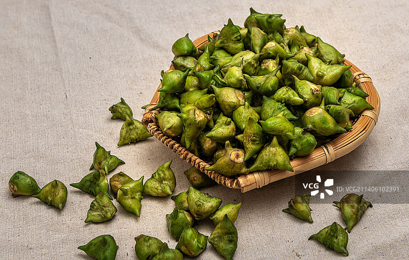装在簸箕里的一堆绿色嫩菱角图片素材