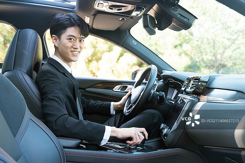 年轻司机在车内手扶方向盘图片素材
