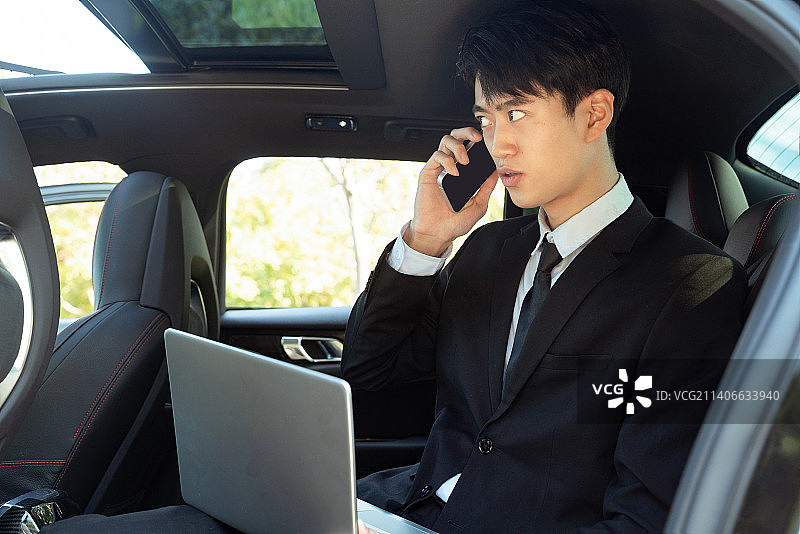 在汽车内办公的商务男士使用手机打电话图片素材