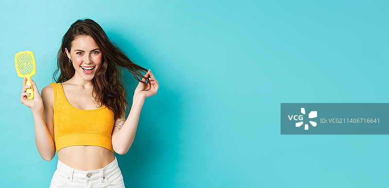 快乐的女人展示没有头发的刷子图片素材