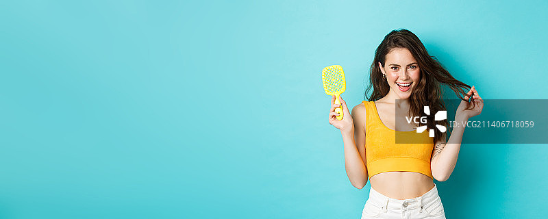 快乐的女人展示没有头发的刷子图片素材