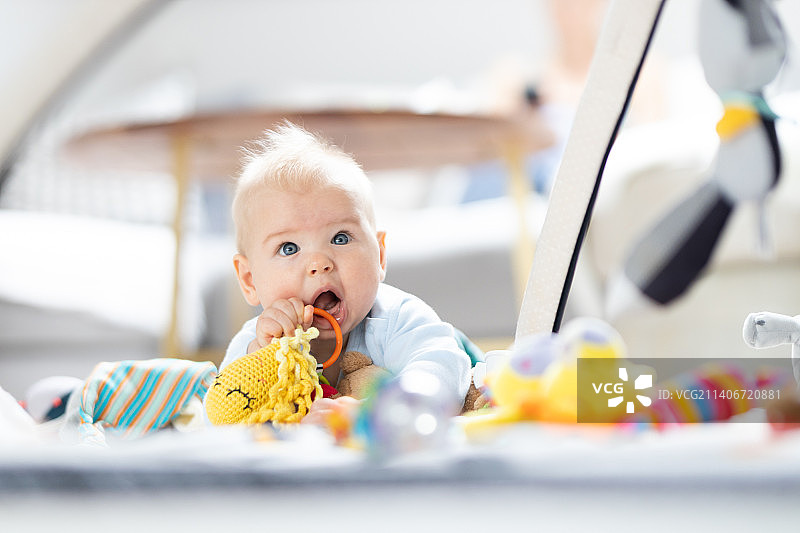 可爱的男婴在家玩悬挂玩具拱形垫图片素材