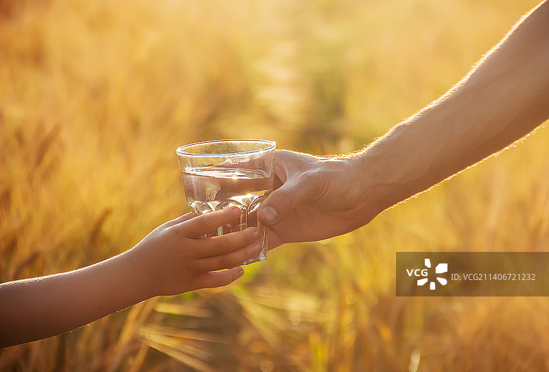 父亲给孩子一杯水（选择性聚焦）图片素材