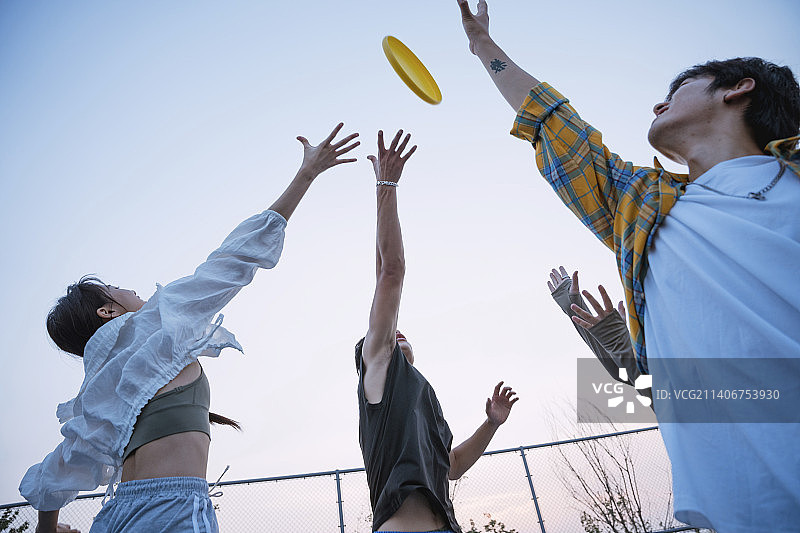 快乐的年轻人在玩飞盘图片素材