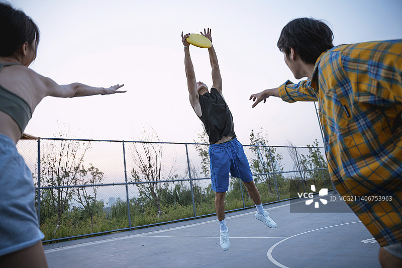 快乐的年轻人在玩飞盘图片素材