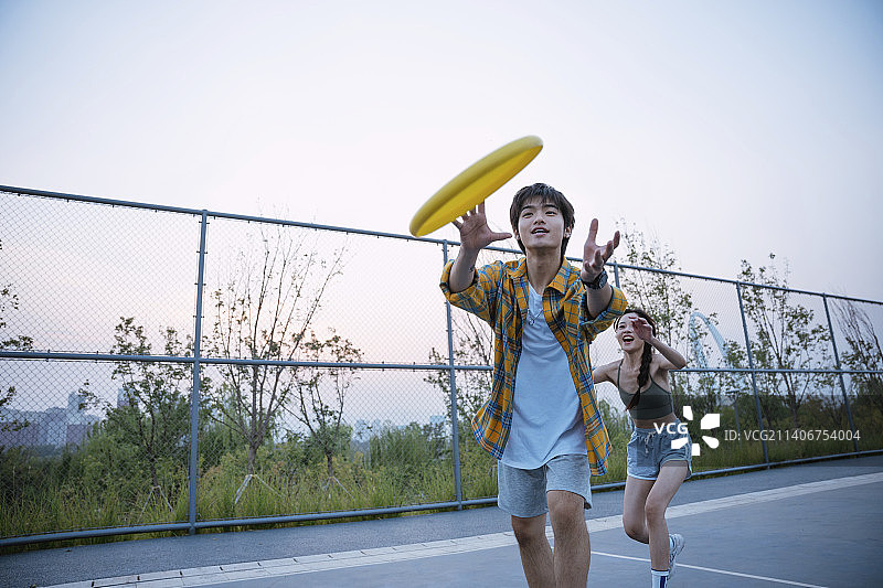 快乐的年轻人在玩飞盘图片素材