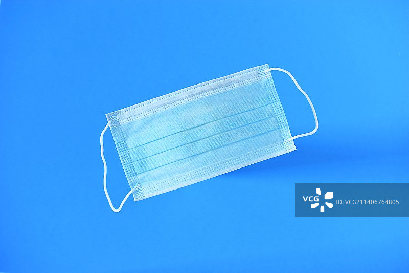 蓝色背景下的医疗口罩，医用外科口罩图片素材