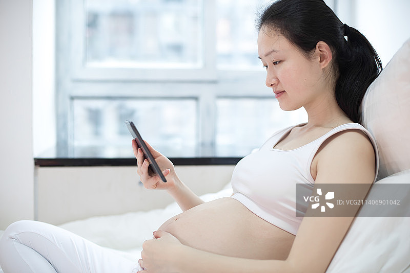 孕妇用手机看视频图片素材