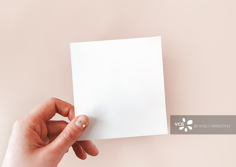 涂有简约自然美甲的女人手持白色物体图片素材