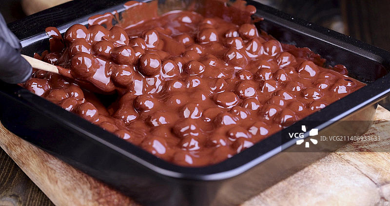 将烤榛子加入融化的液态巧克力中图片素材