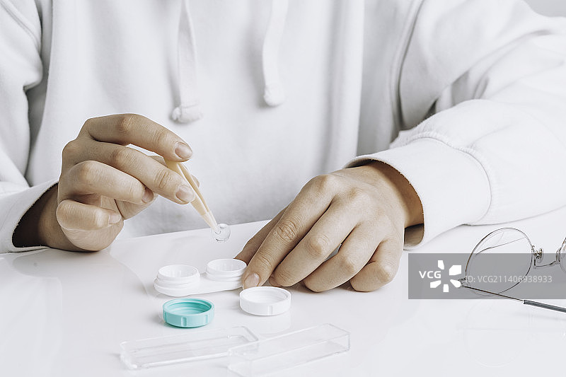 女性用镊子戴隐形眼镜特写图片素材