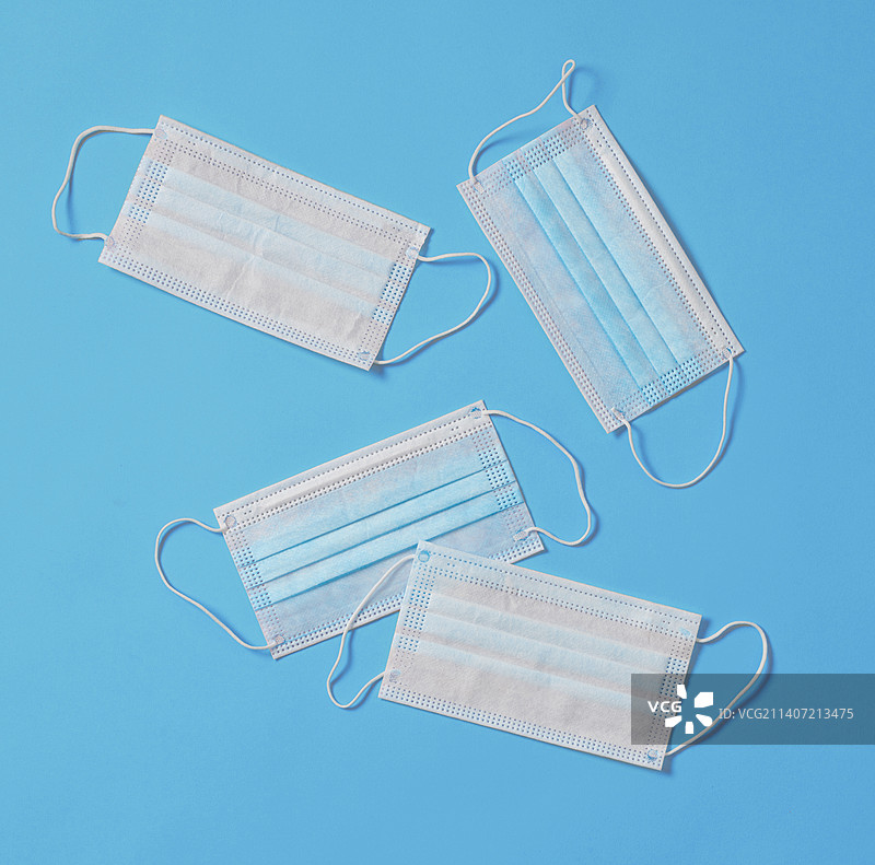 蓝色背景下的一次性医用外科口罩图片素材
