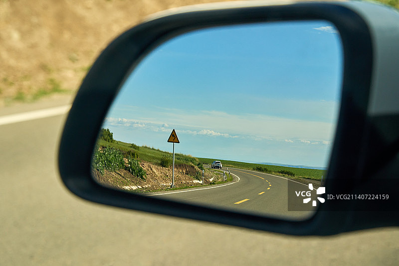 旅行路上后视镜里的公路拐弯风景图片素材