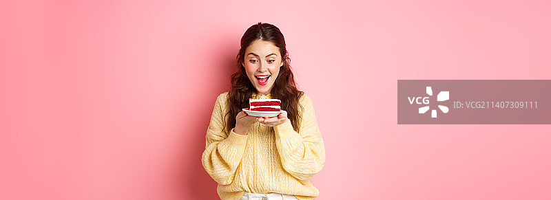 盯着美味生日蛋糕的快乐女孩图片素材