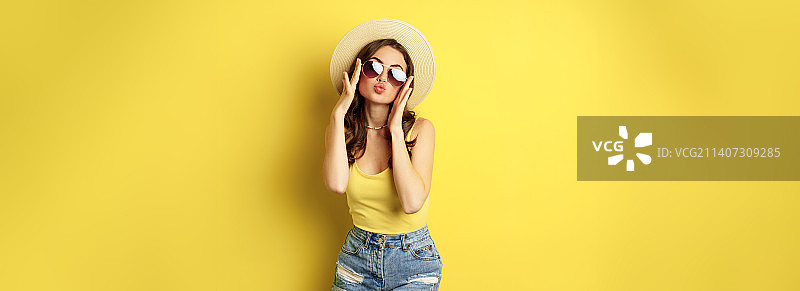 戴着草帽和太阳镜的快乐年轻女子在度假图片素材