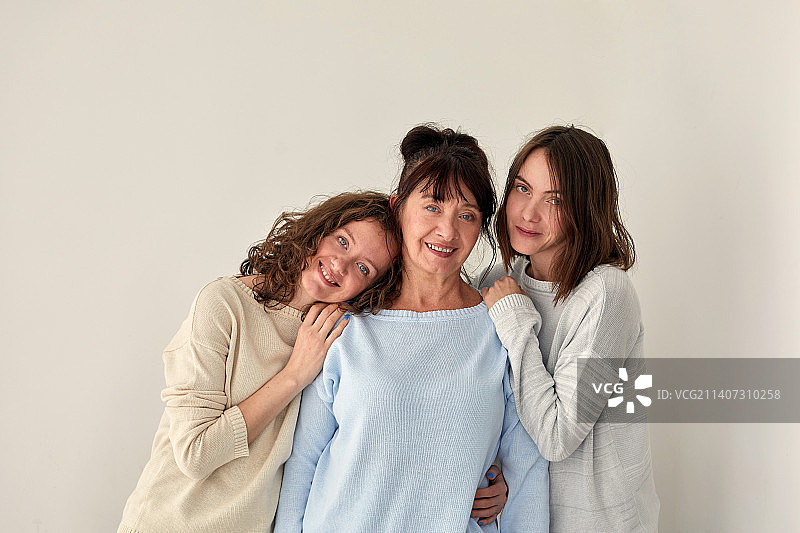 微笑的母亲拥抱女儿并看着镜头图片素材