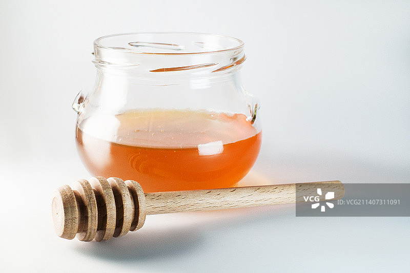 白色背景上的蜂蜜勺特写图片素材