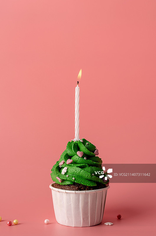 粉色背景上的圣诞树纸杯蛋糕图片素材