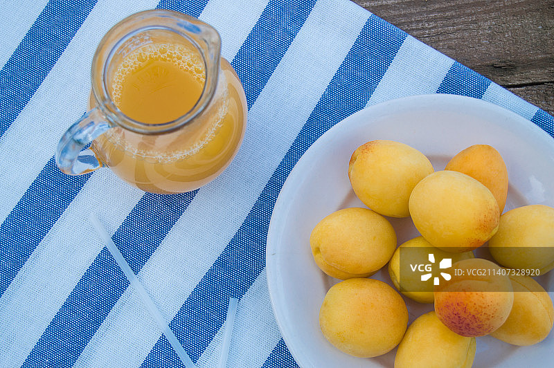 玻璃罐里的杏子汁和餐巾上的水果，顶视图图片素材