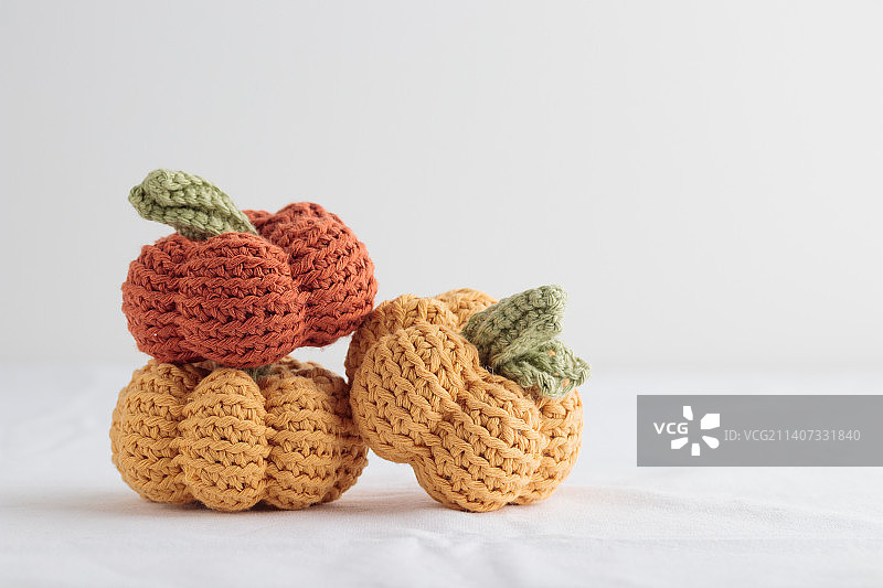 白色背景上可爱的钩针编织黄色和橙色南瓜图片素材