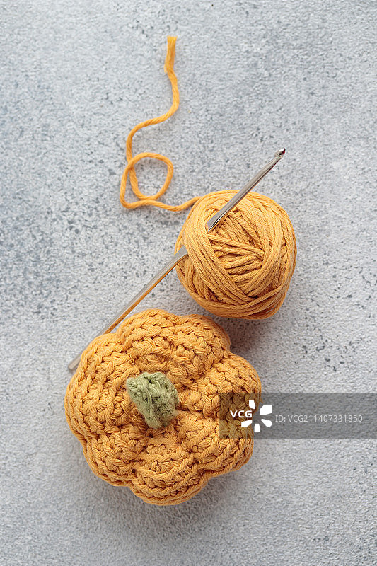 灰色背景上可爱的钩针编织黄色南瓜图片素材