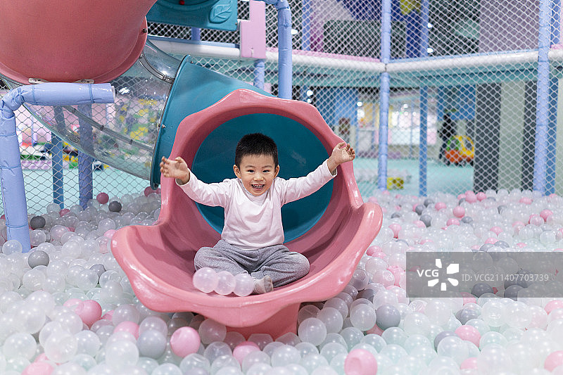 坐在滑梯上的小男孩图片素材